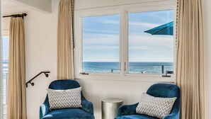 A room with two blue velvet armchairs, a small round side table, and a window with a view of the sea. - Luxury, renovated, oceanfront home with incredible deck & ocean views - dog friendly! (La Jolla)