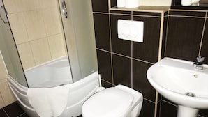 A bathroom with a bathtub, toilet, and sink.