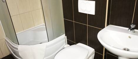 A bathroom with a bathtub, toilet, and sink.