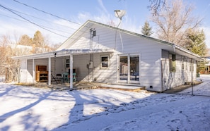 A single-story house with a covered porch, a satellite dish, and a fenced yard. - Bison Hills- Walk to historic downtown Cody, Pet Friendly (Cody)