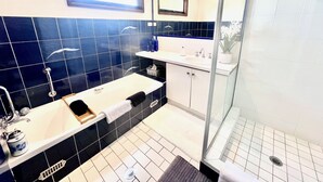 Un baño moderno con una bañera grande, lavamanos doble y cabina de ducha de vidrio.