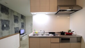 A compact kitchen with a built-in sink, a stove, and a small countertop area. - Tsuruhashi East III (Osaka)