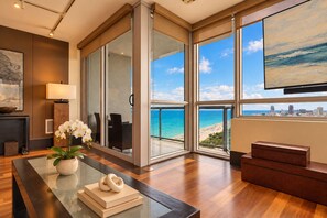 Amplia habitación con un gran ventanal corredero que da a un balcón con vistas a la ciudad y a la playa.