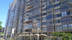 A multi-story residential building with balconies, a covered entrance, and a clear sky. - A Two-bedroom Holiday Apartment, at the Heart of South Beach Durban (Durban)