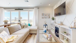 A modern living room with a sofa, coffee table, and a fireplace. - Resort Style Pools, Boardwalk to the Beach (Port Aransas)