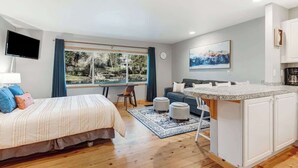 Une chambre moderne avec un lit, un bureau et une vue sur l’extérieur.