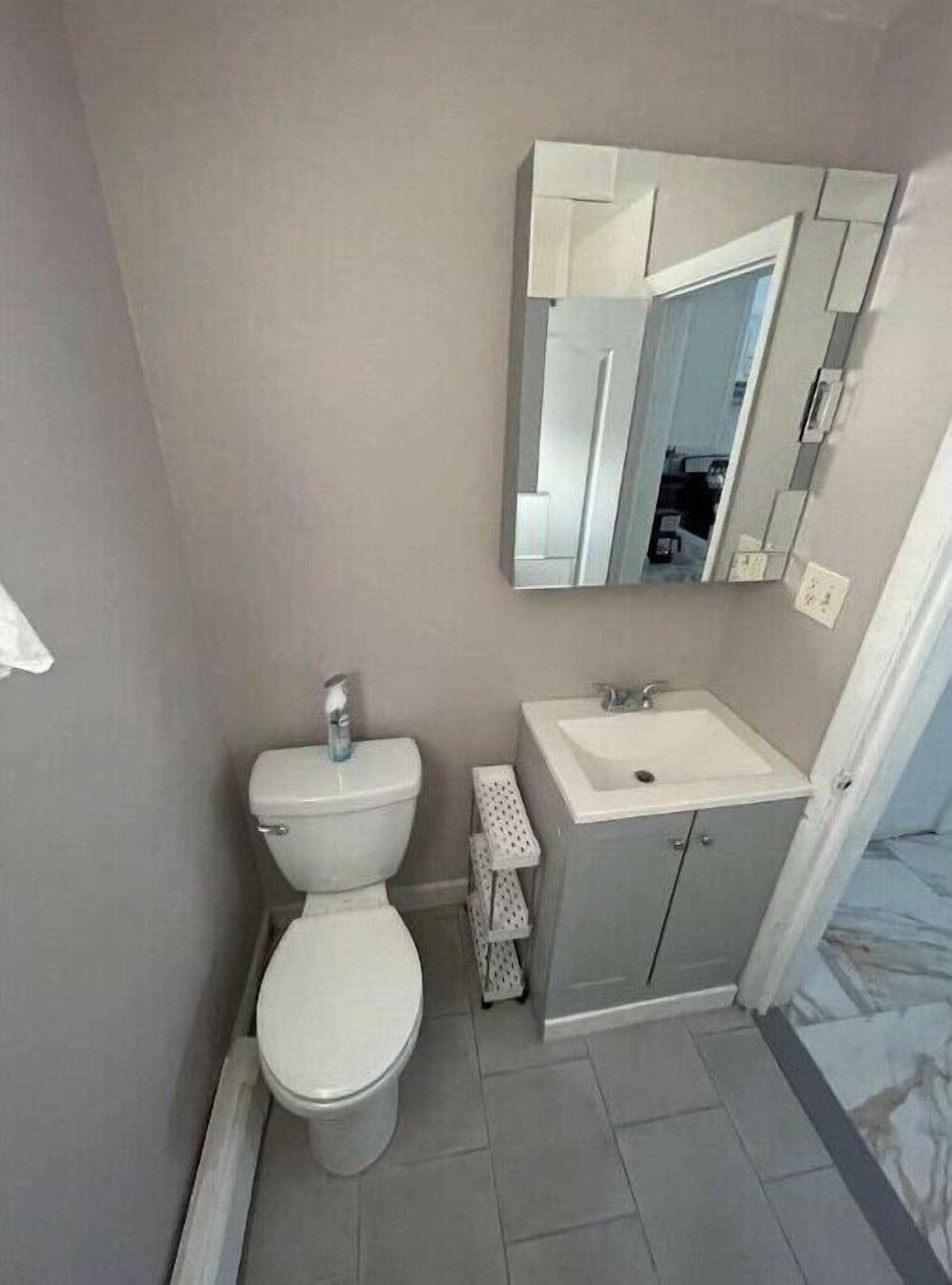 Une salle de bain avec des toilettes, un lavabo et un miroir.