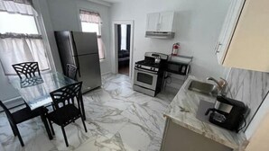 Cozinha compacta com geladeira, fogão, micro-ondas e pia.