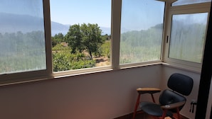 Une chambre avec vue sur un vignoble, grâce à de grandes fenêtres.