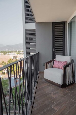 Un balcon avec une chaise et une vue sur le paysage urbain.