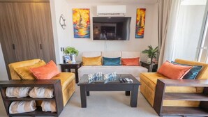 Una sala de estar moderna con un conjunto de sofás, una mesa de centro y un televisor de pantalla plana.