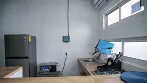 Una cocina compacta con refrigerador, tostadora, pileta y ventana.