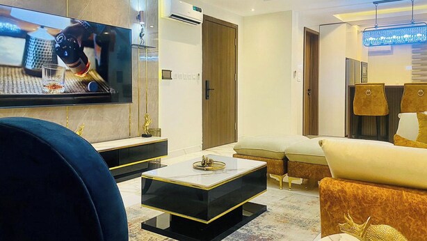 A modern living room with a flat-screen TV, a coffee table, sofas, and a lamp. - 2 Bed Apartment Sleeps 4 - Pool - Free Parking (Lekki 1)