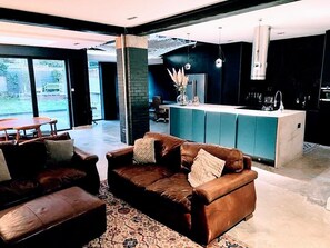Un salon moderne avec un canapé en cuir marron, une table basse et un tapis à motifs.