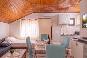 Um espaço compacto com cozinha compacta, área de refeições e quarto.