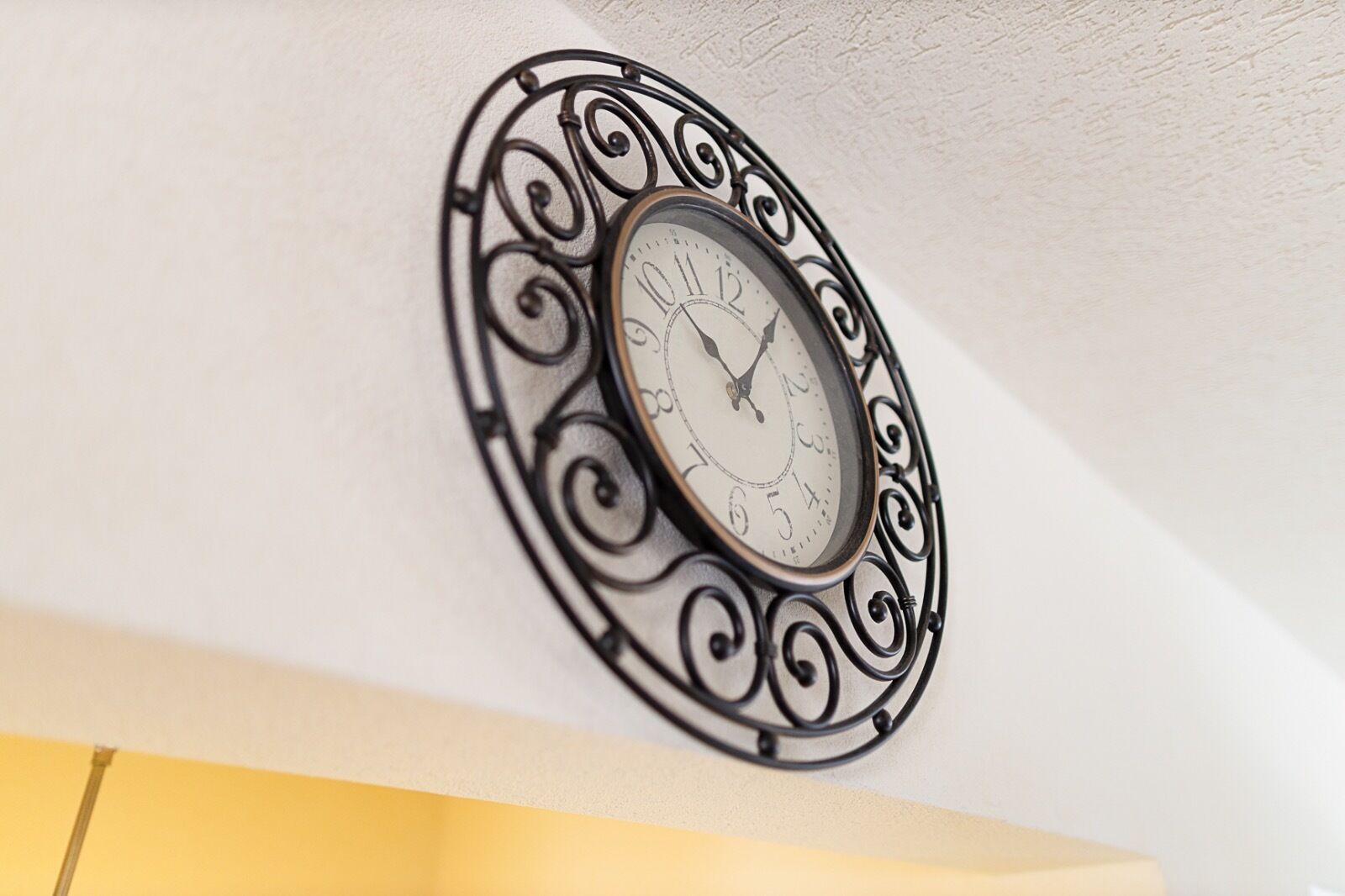 A wall-mounted clock with a decorative metal frame.