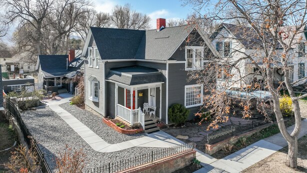 A two-story house with a front porch, a covered patio, and a driveway.