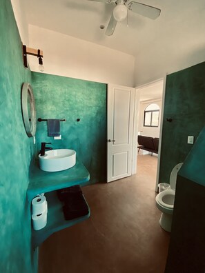 A bathroom with a white sink, a mirror, and a ceiling fan.