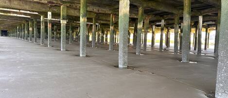 An abandoned building with a long corridor and numerous columns.