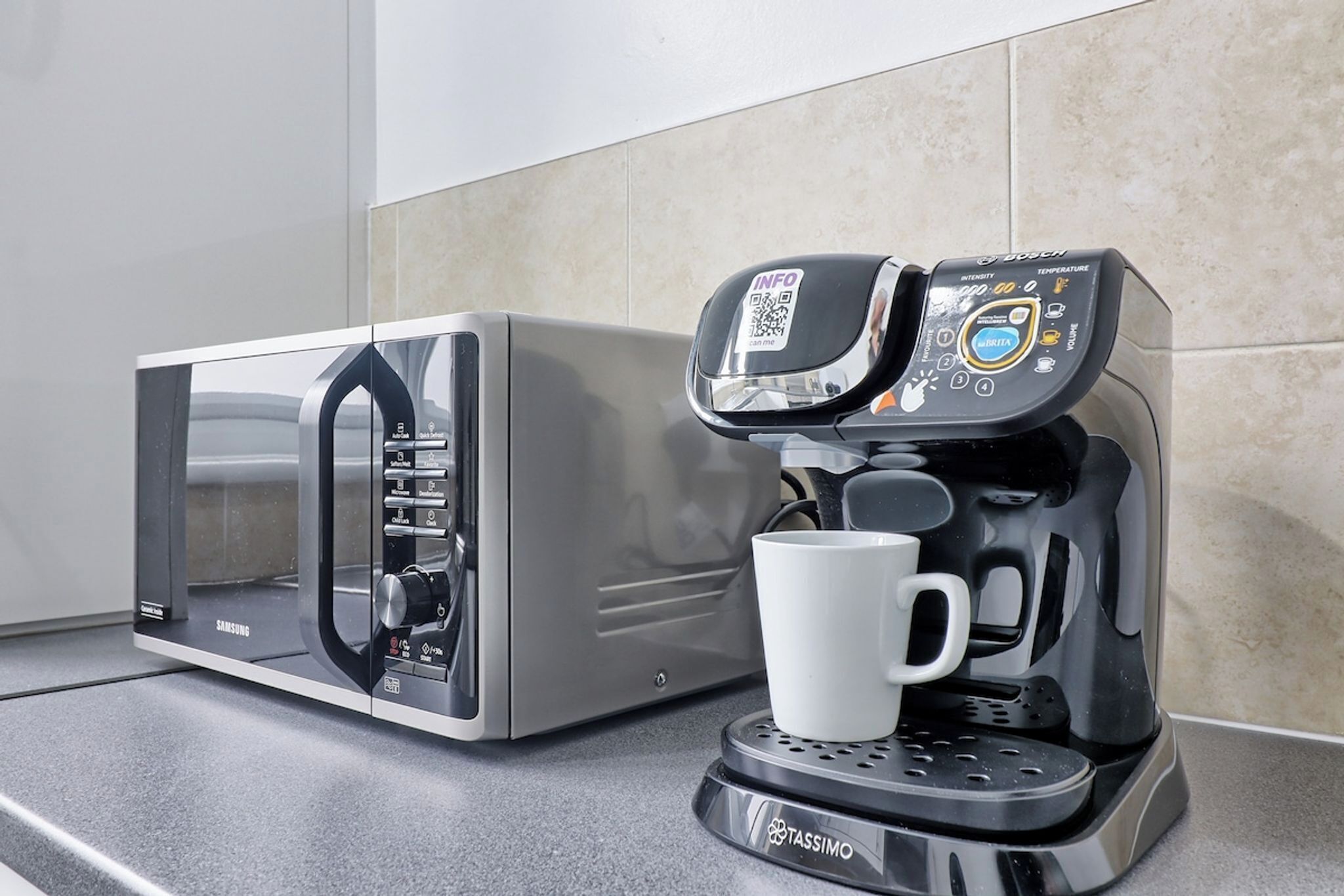 A modern kitchen with a microwave and a coffee maker.