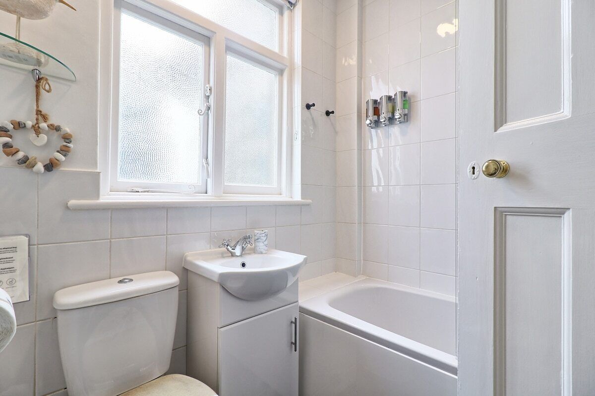 A bathroom with a toilet, sink, and bathtub.