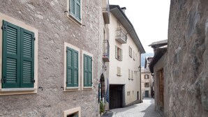 A narrow cobblestone street flanked by historic buildings with shuttered windows and a small balcony. - Bruni 2 in Bormio With 1 Bedrooms and 1 Bathrooms (Bormio)