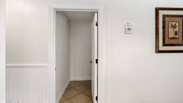 Ein Flur mit einer zur Tür geöffneten Zimmertür, einem gerahmten Bild an der Wand und einem Thermostat.