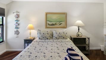 Ein Schlafzimmer mit einem Bett, zwei Nachttischen, einem Fenster und einem Wandbild.