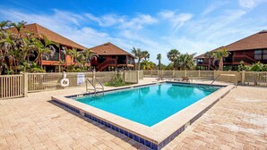 Una piscina rectangular con borde de azulejos, rodeada por un patio de ladrillo.