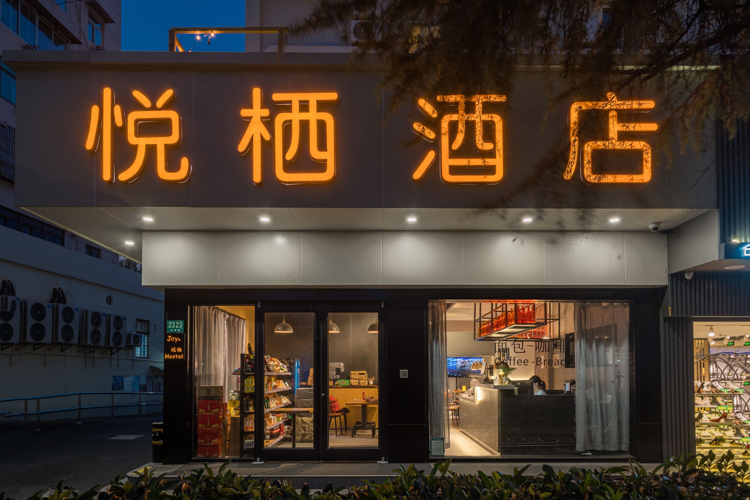A hotel with a neon sign, a visible entrance, and a visible reception desk.