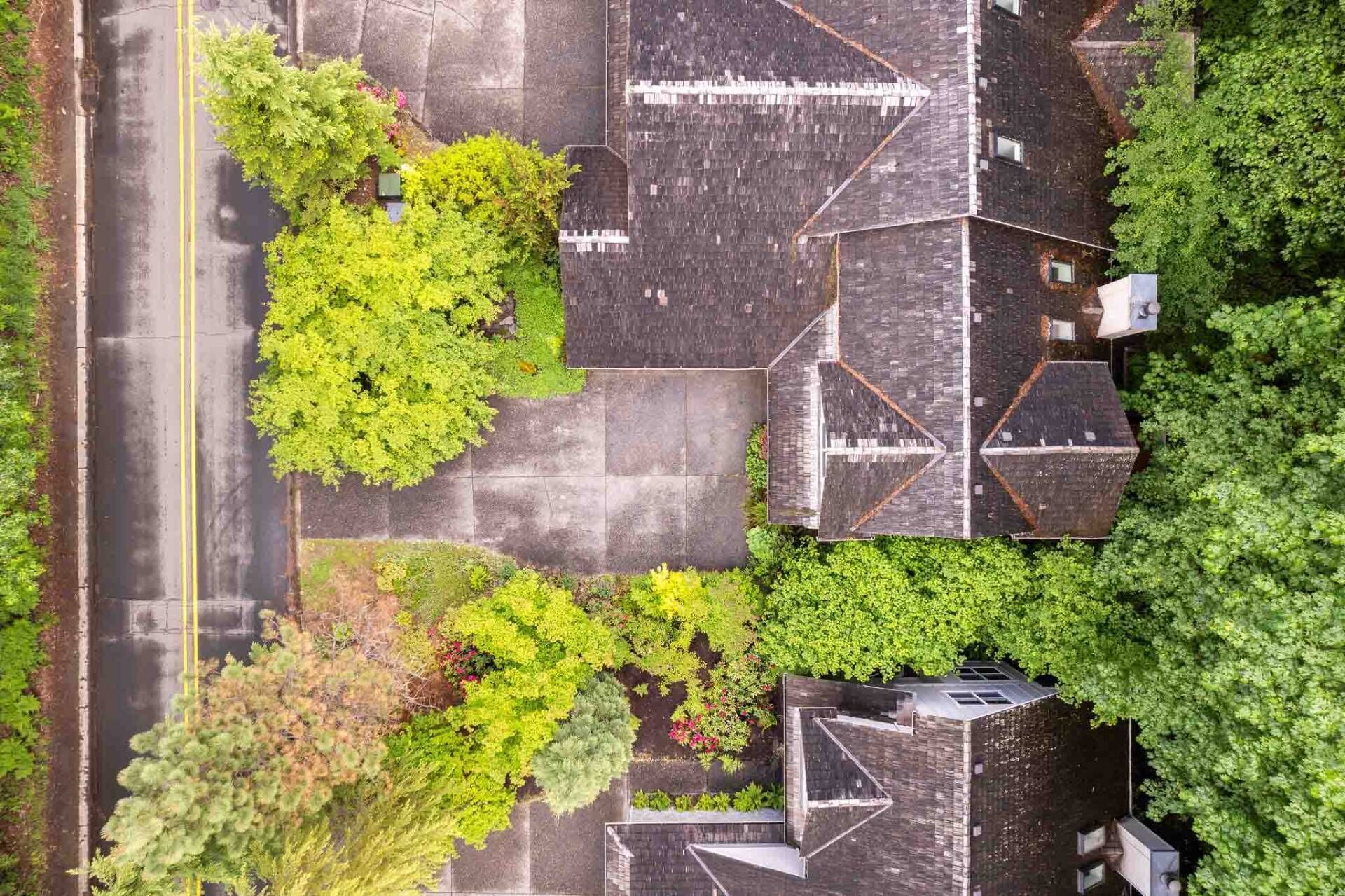 An aerial view of a parking lot with trees and buildings.