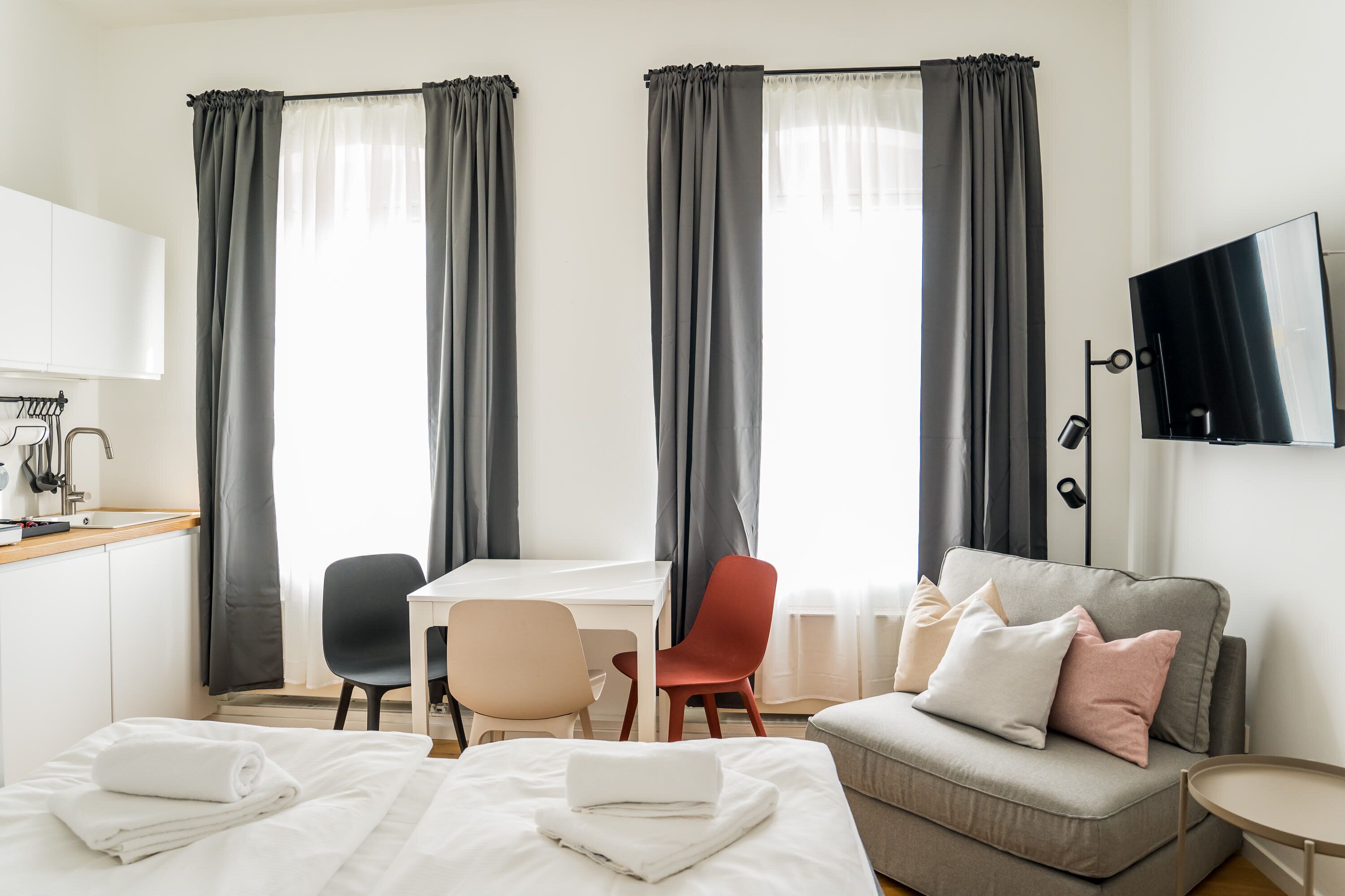 Ein Hotelzimmer mit einem Bett, einem Schreibtisch, einem Sessel, einem Sofa und einem Fernseher.