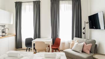 Ein Hotelzimmer mit einem Bett, einem Schreibtisch, einem Sessel, einem Sofa und einem Fernseher.