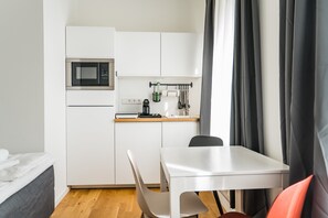 Enjoy a compact kitchenette with a microwave, coffee machine, and dining area.