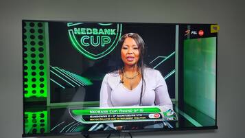 A television displaying the Nedbank Cup, with a sports news anchor.