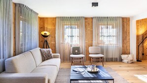 Un salon comprenant un canapé, deux fauteuils, une table basse et une lampe.