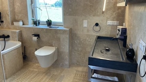 Une salle de bain avec des toilettes, un lavabo et une fenêtre.