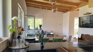Une cuisine dotée d’un plan de travail noir, d’un évier et d’un coin repas avec une table et des chaises.