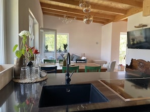 A kitchen with a black countertop, a sink, and a dining area with a table and chairs.