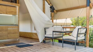 A wooden deck with a table and chairs, a tent structure, and a wooden cabinet. - Holiday Home 'Safarizelt' with Private Terrace, Wi-Fi and Air Conditioning (Großenbrode)