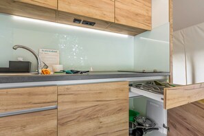 Une cuisine moderne avec des meubles en bois, un évier en acier inoxydable et un lave-vaisselle encastré.