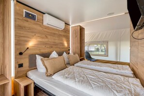 Une chambre à coucher moderne avec une tête de lit en bois, un lit avec une literie blanche, une table de chevet et une chaise.
