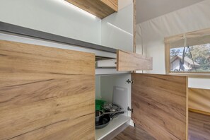 Une cuisine de taille réduite, dotée de meubles en bois et d’une fenêtre offrant une vue sur l’extérieur.