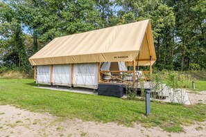 A tented accommodation with a canvas roof and a wooden frame structure. - Holiday Home 'Safarizelt' with Private Terrace, Wi-Fi and Air Conditioning (Großenbrode)