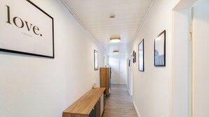 Een gang met lijstwerken, een houten bankje en een bord waarop staat 'liefde. dat is alles wat je nodig hebt'.