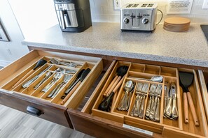 Una cocina con un organizador de cajones que contiene cubiertos y una tostadora sobre la encimera.