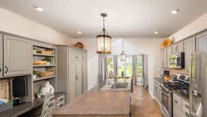 A kitchen with a central island, stainless steel appliances, and a view to the outdoors. - Renovated Farmhouse w/ Game Barn & Firepit (Appleton)