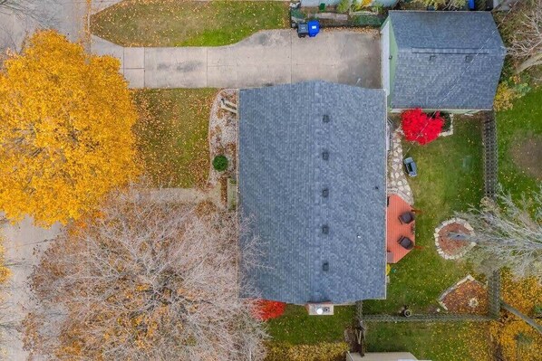 An aerial view of a residential property with a large house, a driveway, and surrounding gardens. - Charming Home in Family Neighborhood w/Fenced Yard (Appleton)