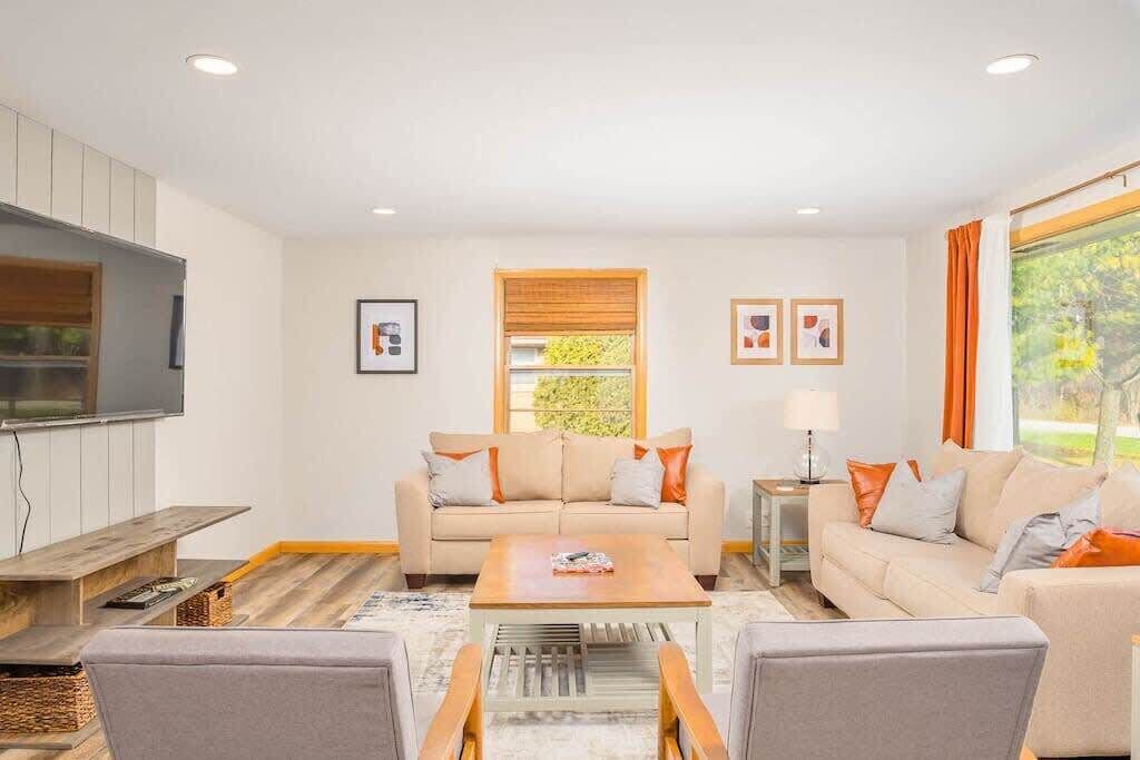 A modern living room with a sofa set, a coffee table, and a TV.