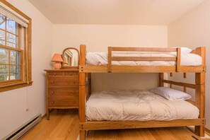 A bunk bed with a wooden frame, a dresser with drawers, a mirror, and a lamp. - Lakefront House w/ Kayaks & Private Dock (Waupaca)